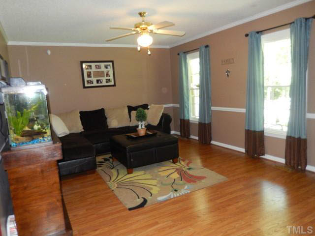 3151 Sanders Road Willow Spring, NC 27592 - Photo 4 of 24 a living room with furniture and a chandelier