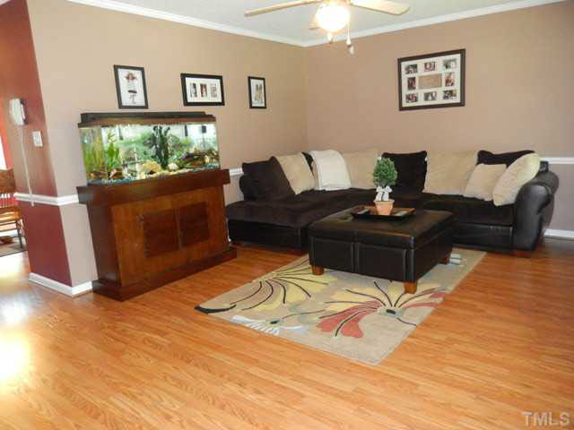 3151 Sanders Road Willow Spring, NC 27592 - Photo 5 of 24 a living room with furniture and a flat screen tv