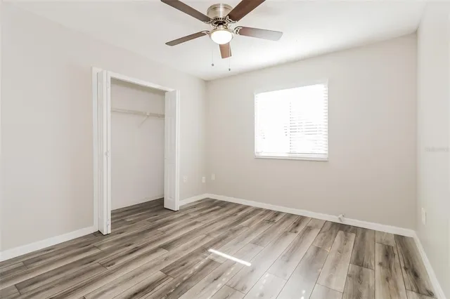 an empty room with a window and a ceiling fan