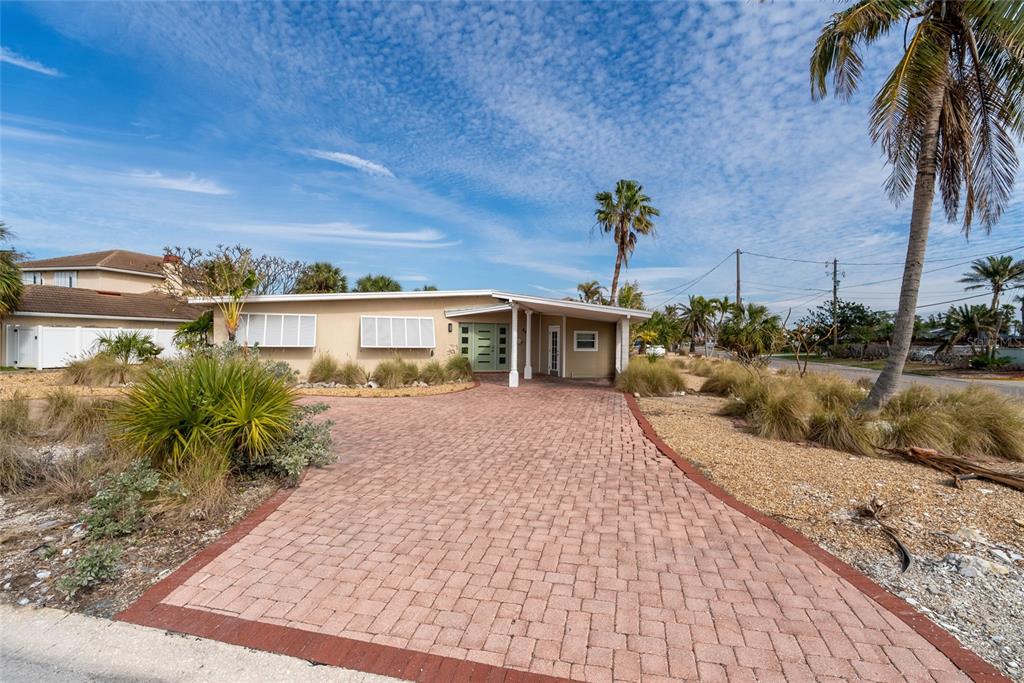 6407 1st Palm Point St. Pete Beach, FL 33706 - Photo 1 of 1 a view of a house with a yard and potted plants
