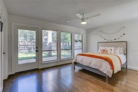 a bedroom with a large bed and wooden floor