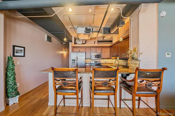 a kitchen with stainless steel appliances granite countertop a refrigerator a sink and a stove