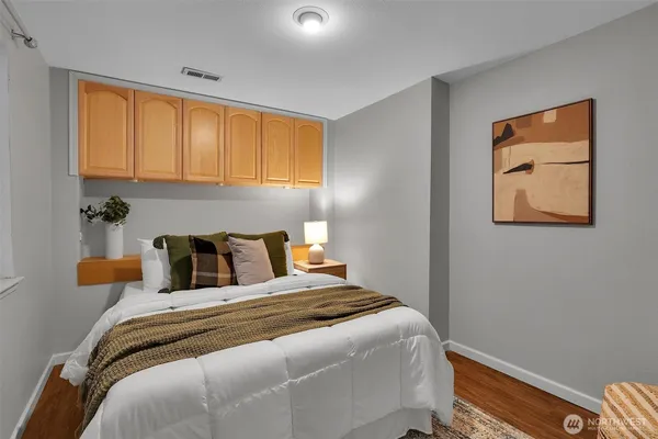 a bedroom with bed and wooden floor