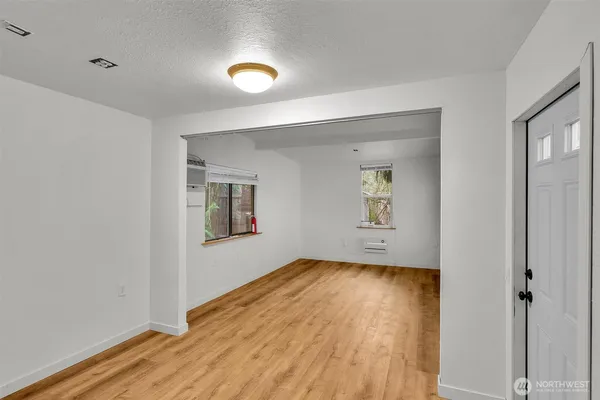 an empty room with wooden floor and windows