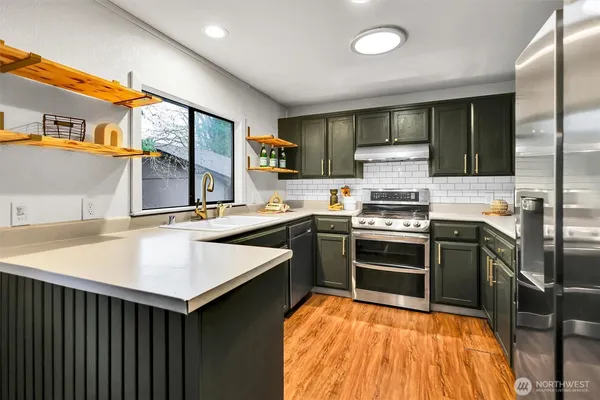 a kitchen with stainless steel appliances granite countertop a sink and stove top oven