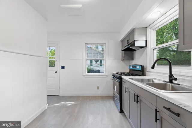 a kitchen with stainless steel appliances a sink cabinets and a window