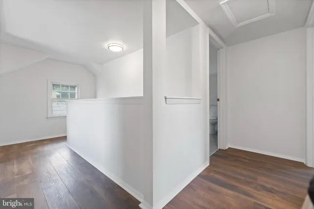 a view of an empty room with wooden floor and closet