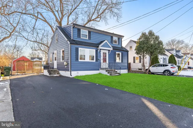 a front view of a house with a garden and trees