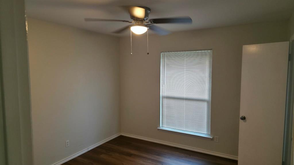 5722 Old Ox Road Dallas, TX 75241 - Photo 6 of 10 an empty room with wooden floor chandelier fan and windows