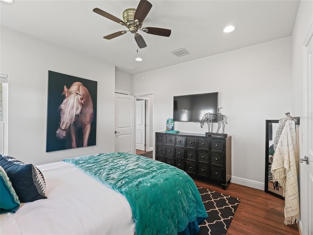 12943 Southeast Sunset Harbor Road Weirsdale, FL 32195 - Photo 41 of 87 a bedroom with a bed and a flat screen tv