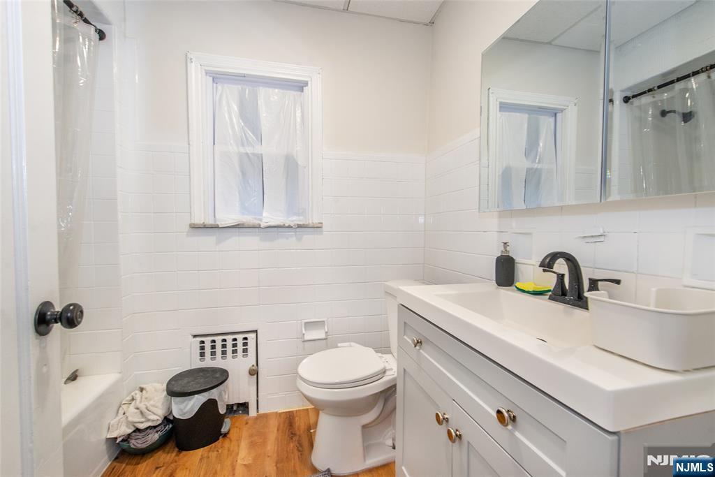 89 King Street Nutley, NJ 07110 - Photo 15 of 32 a bathroom with a toilet a sink and mirror