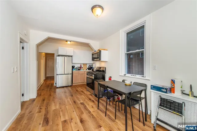a kitchen with a table chairs refrigerator and a sink