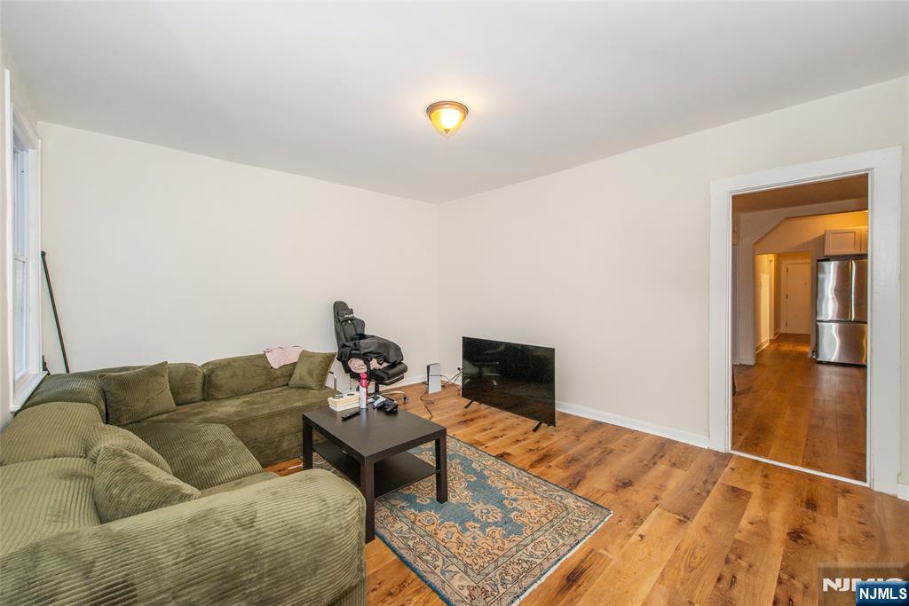 89 King Street Nutley, NJ 07110 - Photo 19 of 32 a living room with a couch and a dining table with wooden floor