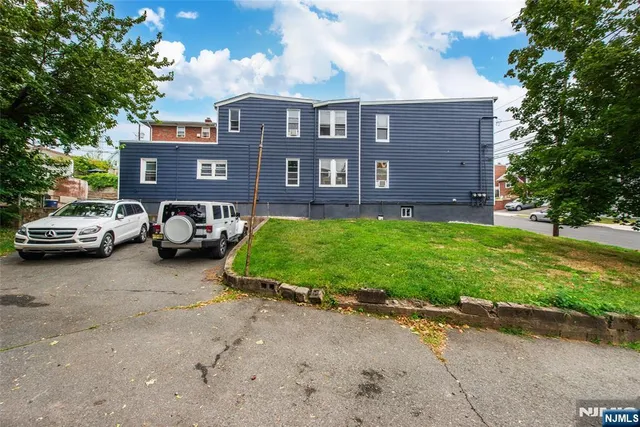a view of a car parked in front of a house with a yard