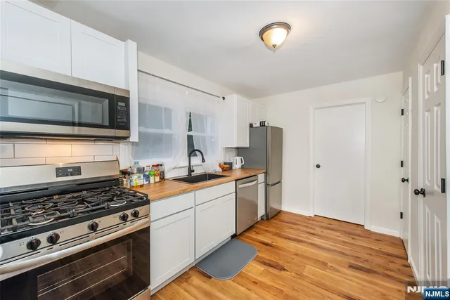 a kitchen with stainless steel appliances a stove microwave and refrigerator