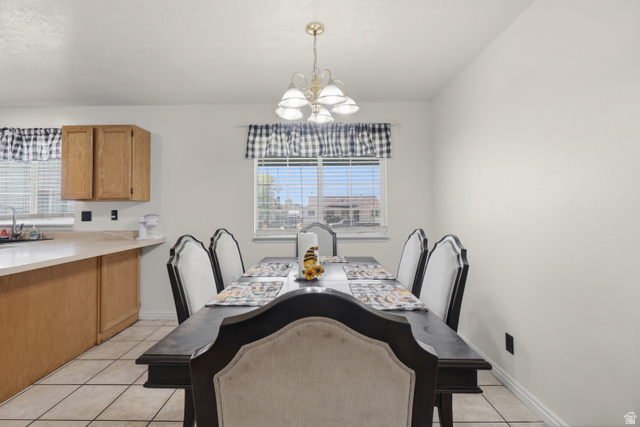 2135 East White Pine Road Eagle Mountain, UT 84005 - Photo 8 of 23 Dining area featuring a central chandelier, multiple windows with horizontal blinds, and tile flooring