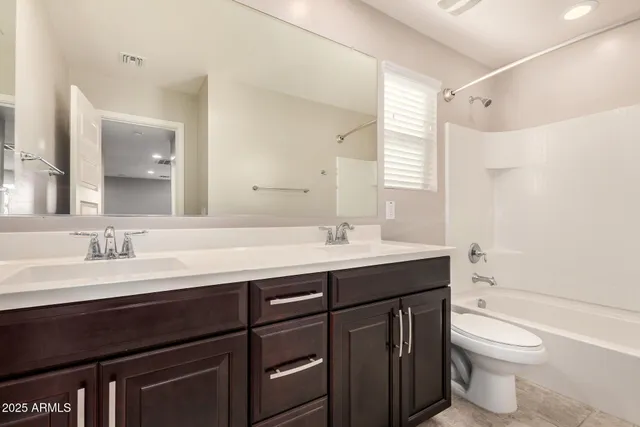 a bathroom with a double vanity sink toilet and a mirror
