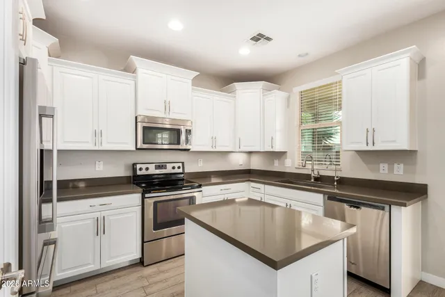 a kitchen with granite countertop a sink stove and microwave