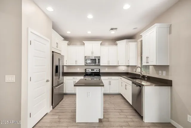 a kitchen with stainless steel appliances granite countertop a refrigerator and a sink