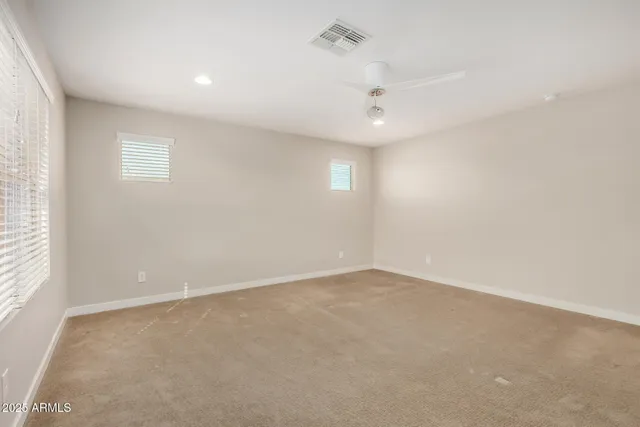 an empty room with a ceiling fan and window