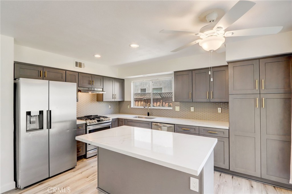 a large kitchen with stainless steel appliances a refrigerator and a sink