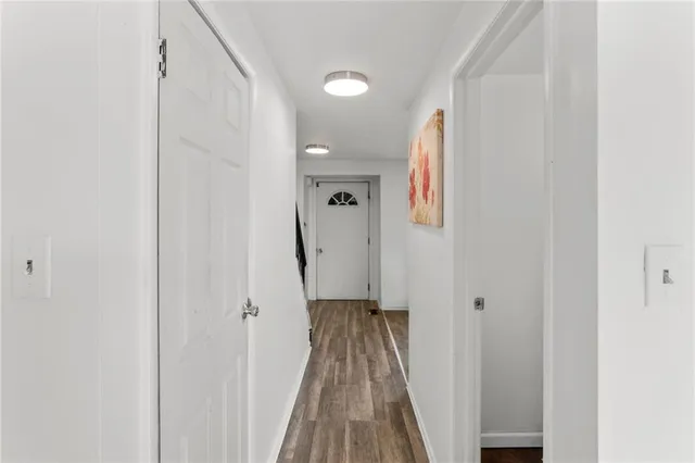 a view of a hallway with wooden floor and staircase