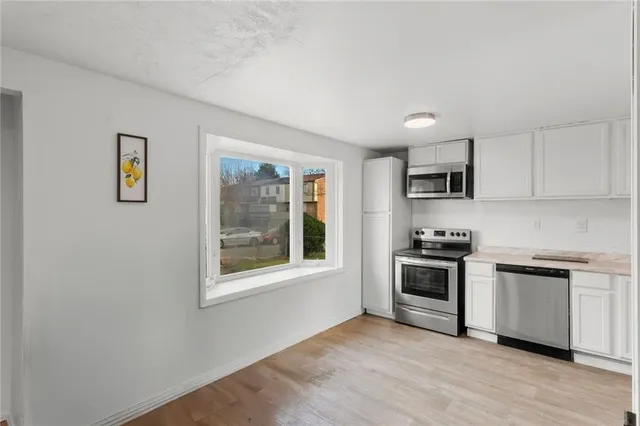 a kitchen with stainless steel appliances granite countertop a stove a sink and a microwave