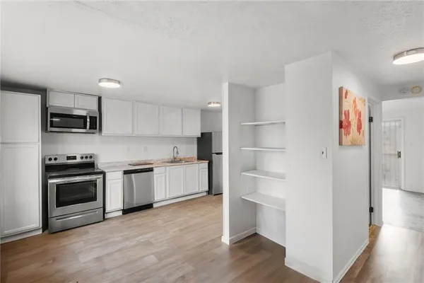 a kitchen with a refrigerator and a stove top oven
