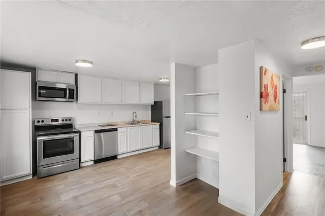a kitchen with a refrigerator and a stove top oven