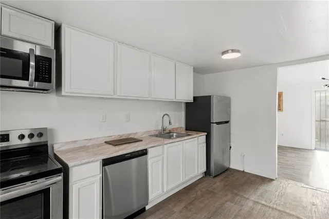 a kitchen with a sink and steel appliances