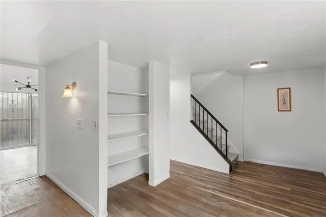 a view of a hallway with wooden floor and staircase