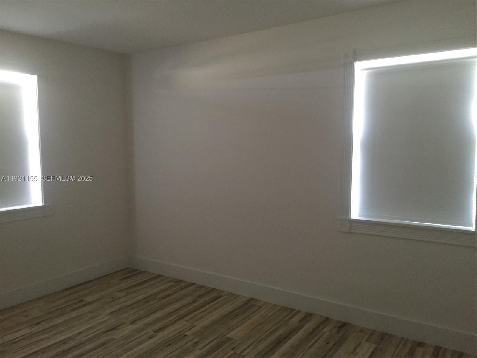 1831 Southwest 17th Terrace Miami, FL 33145 - Photo 9 of 21 an empty room with wooden floor and windows
