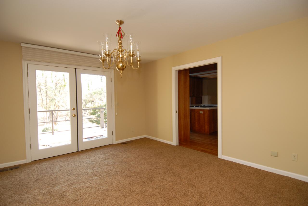 15855 Montgomery Ranch Road Redding, CA 96001 - Photo 9 of 12 an empty room with windows and chandelier