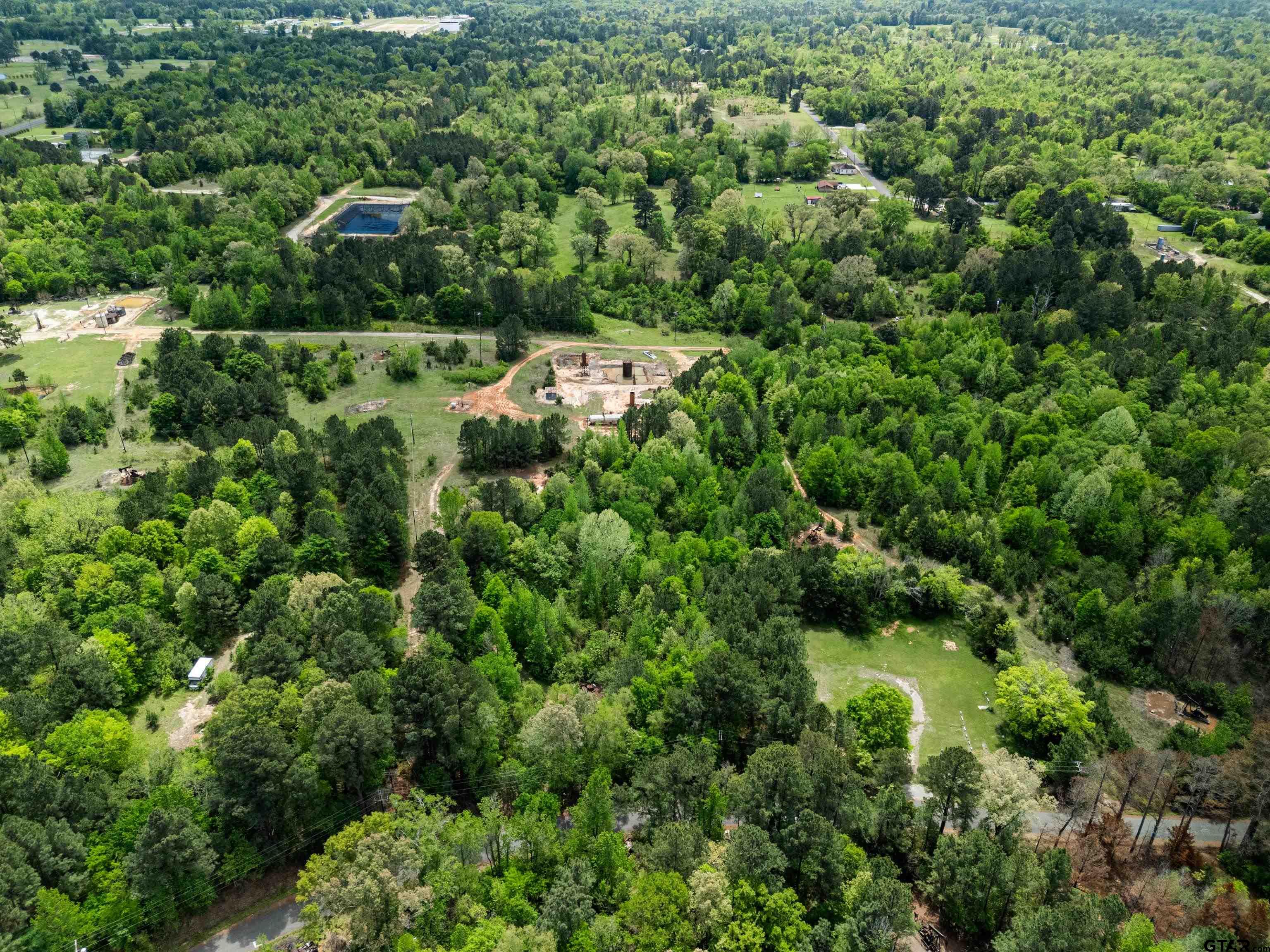 an aerial view of residential house with outdoor space and trees all around