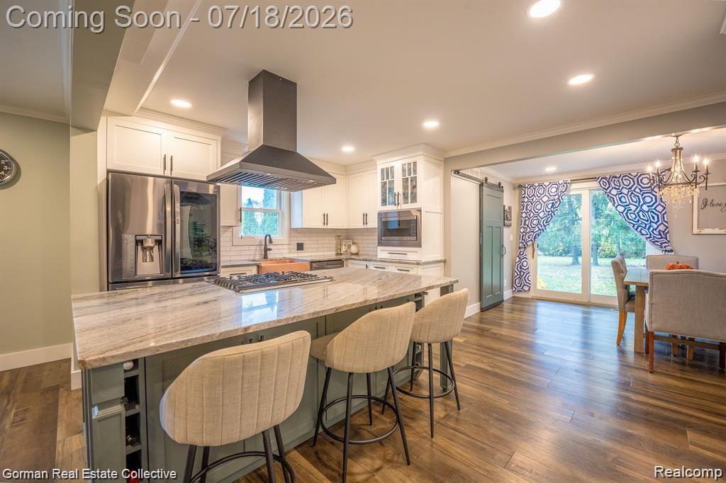 283 Phillips Avenue Clawson, MI 48017 - Photo 9 of 26 Massive island. Custom omega cabinetry, gun metal stainless steel LG suite of appliances, copper sink, gorgeous granite, subway tile, custom glass inside cabinets