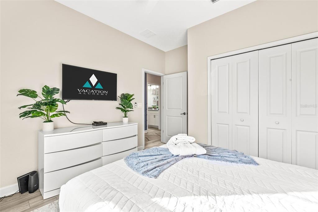 4895 Romeo Circle Kissimmee, FL 34746 - Photo 13 of 93 a bedroom with a white bed and a potted plant