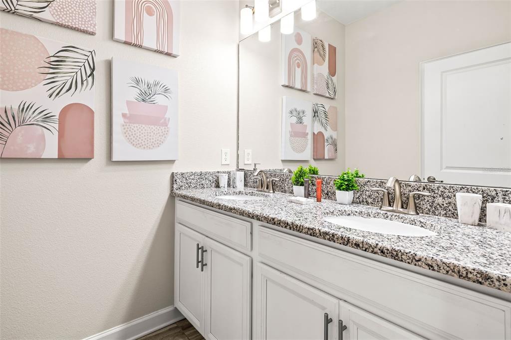 4895 Romeo Circle Kissimmee, FL 34746 - Photo 18 of 93 a bathroom with a granite countertop sink and a mirror