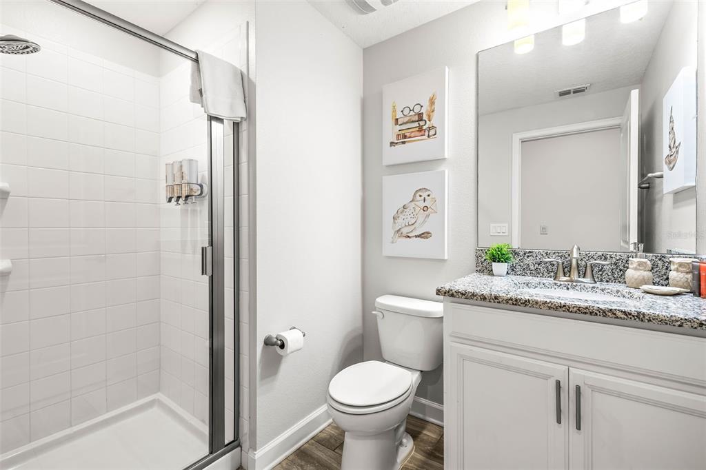 4895 Romeo Circle Kissimmee, FL 34746 - Photo 28 of 93 a bathroom with a granite countertop toilet sink and shower