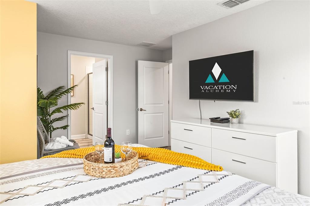 4895 Romeo Circle Kissimmee, FL 34746 - Photo 30 of 93 a bedroom with a bed and a flat screen tv