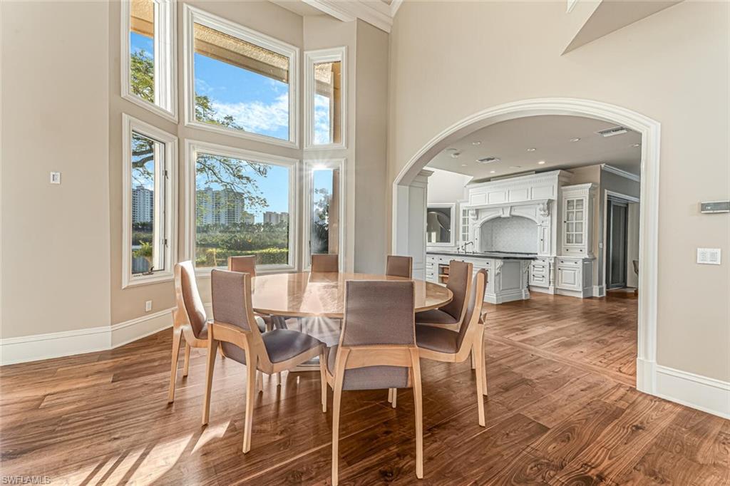 7331 Tilden Lane Naples, FL 34108 - Photo 12 of 50 a dining room with furniture a chandelier and wooden floor