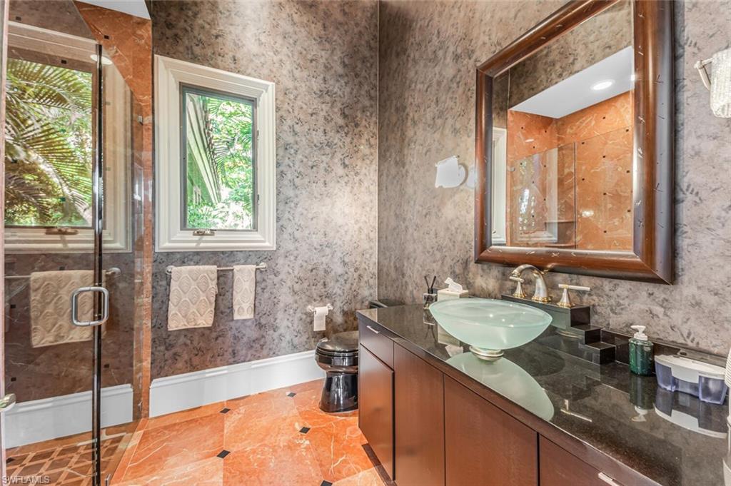 7331 Tilden Lane Naples, FL 34108 - Photo 25 of 50 a bathroom with a granite countertop tub sink and mirror