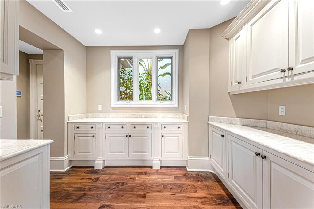7331 Tilden Lane Naples, FL 34108 - Photo 28 of 50 a view of a kitchen with white cabinets and wooden floor