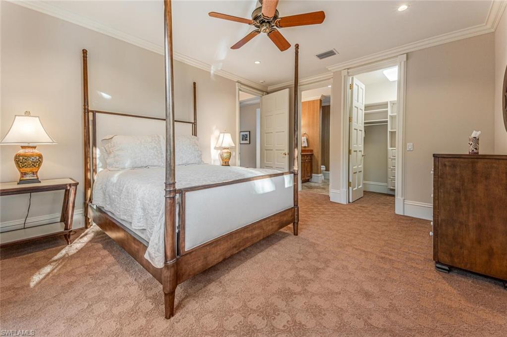 7331 Tilden Lane Naples, FL 34108 - Photo 35 of 50 a spacious bedroom with a bed a table and potted plant
