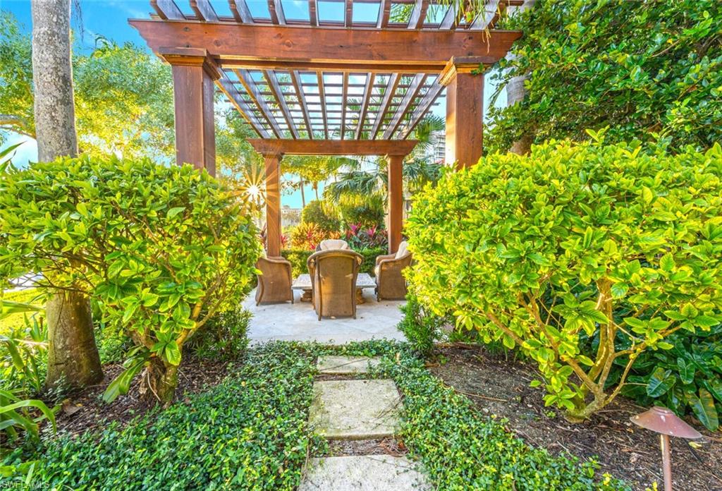 7331 Tilden Lane Naples, FL 34108 - Photo 46 of 50 a porch with table and chairs and potted plants