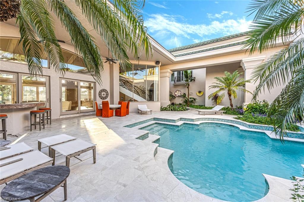 7331 Tilden Lane Naples, FL 34108 - Photo 7 of 50 a view of a swimming pool with a lounge chairs