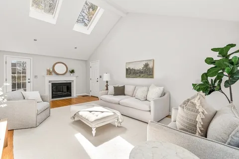 a living room with furniture a fireplace and a window