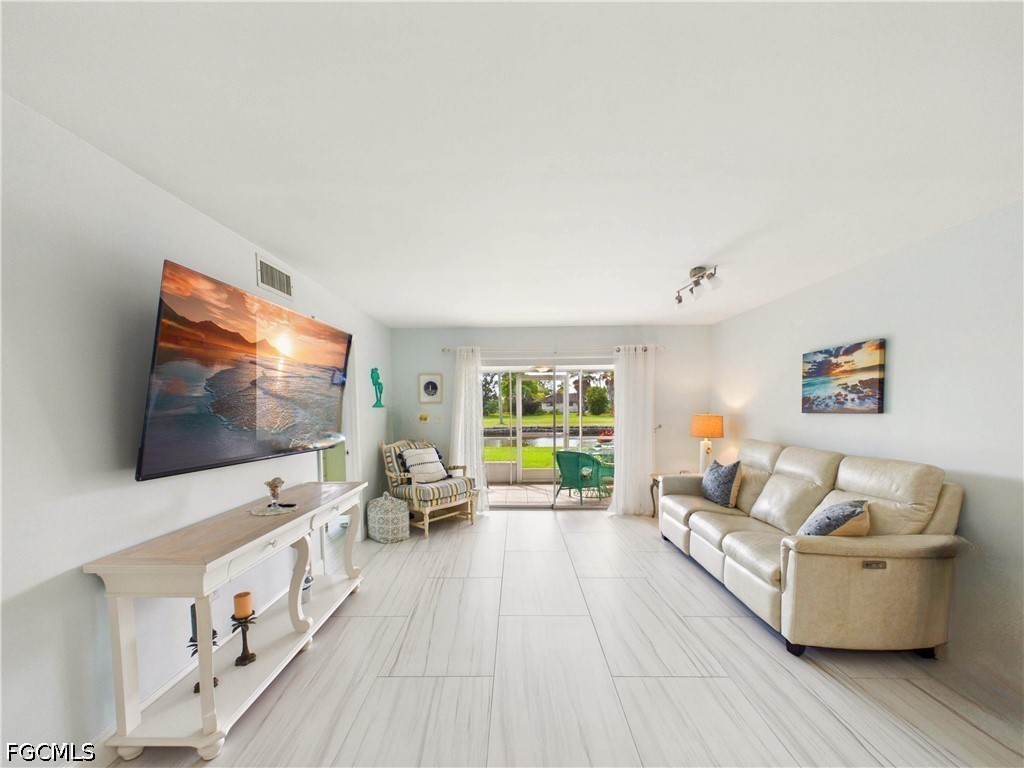 300 Valley Stream Drive, Unit 3D Naples, FL 34113 - Photo 2 of 21 a living room with furniture and a flat screen tv