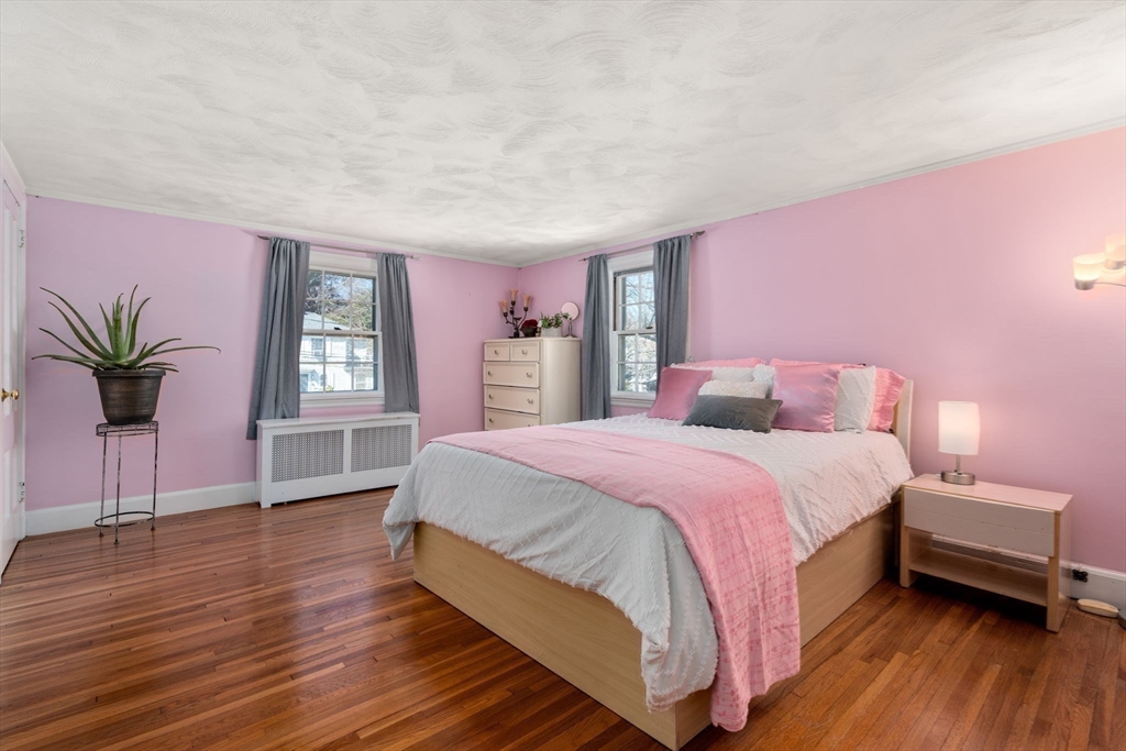 46 Leewood Road Wellesley, MA 02482 - Photo 11 of 16 a spacious bedroom with a bed a window and potted plant on a wooden floor