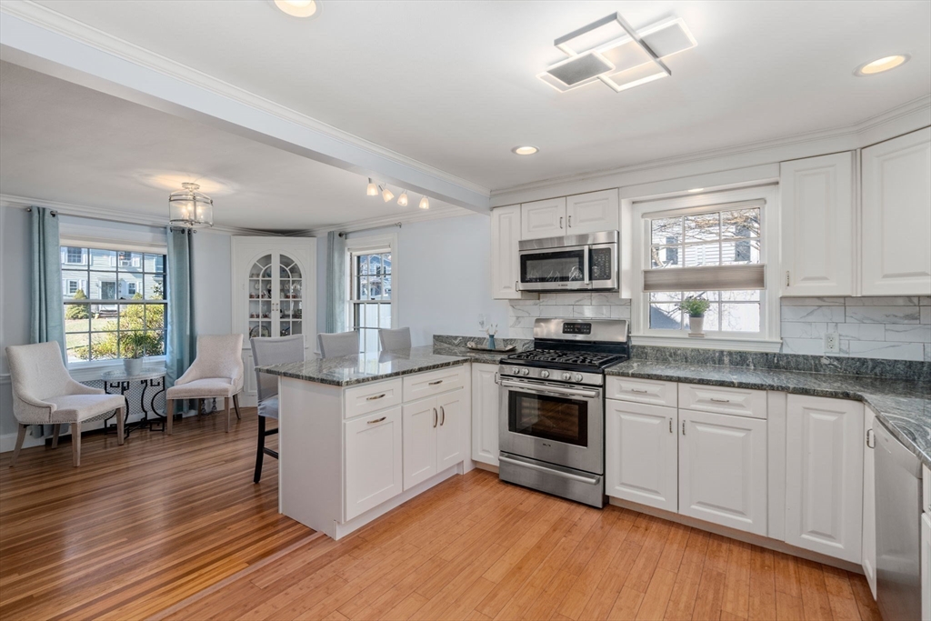 46 Leewood Road Wellesley, MA 02482 - Photo 3 of 16 a kitchen with granite countertop a stove top oven a sink dishwasher and white cabinets with wooden floor