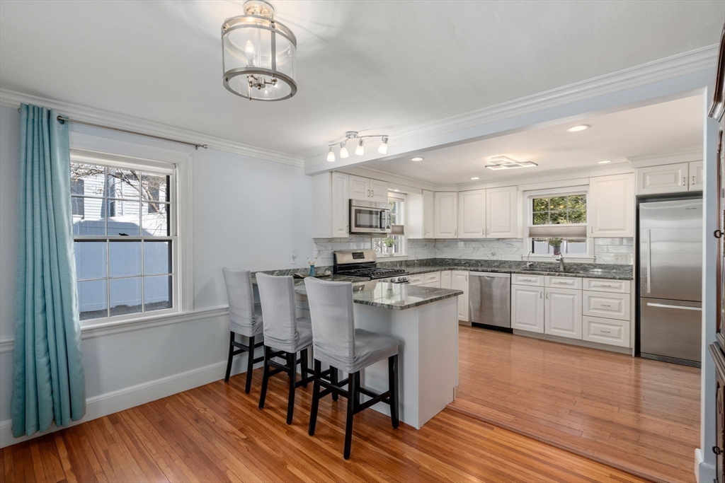 46 Leewood Road Wellesley, MA 02482 - Photo 4 of 16 a kitchen with stainless steel appliances granite countertop a dining table chairs microwave and cabinets